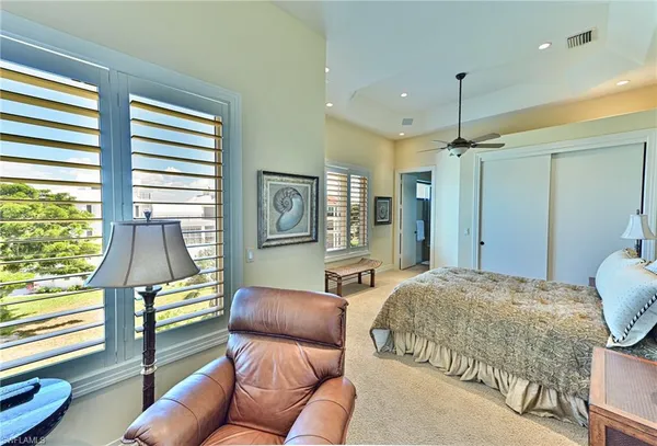 a bedroom with a bed mirror and a large window