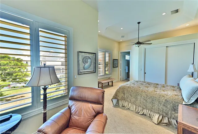 a bedroom with a bed mirror and a large window