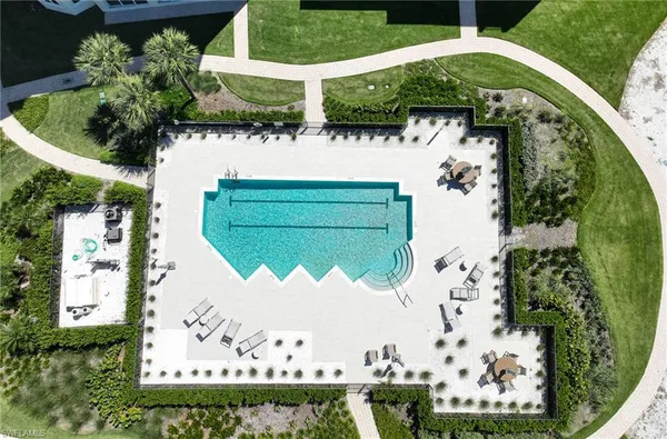 an aerial view of a house with a yard and a large pool