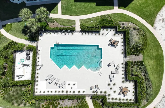 an aerial view of a house with a yard and a large pool