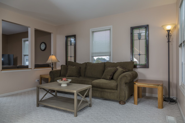 101 Barnes Road Elgin, IL 60124 - Photo 3 of 22 a living room with furniture a lamp paintings and a window