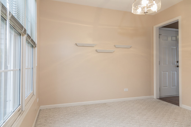 101 Barnes Road Elgin, IL 60124 - Photo 8 of 22 an empty room with a windows and chandelier fan