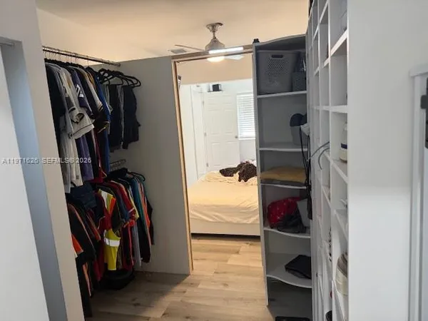 a view of walk in closet with clothes and shoes