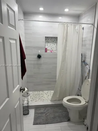a bathroom with a toilet and a shower