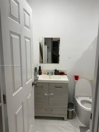 a bathroom with a sink toilet and mirror