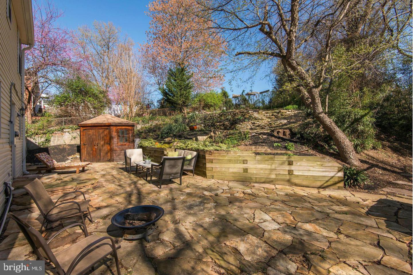 7007 Grove Road Alexandria, VA 22306 - Photo 3 of 15 Terraced backyard and stone patio with a shed