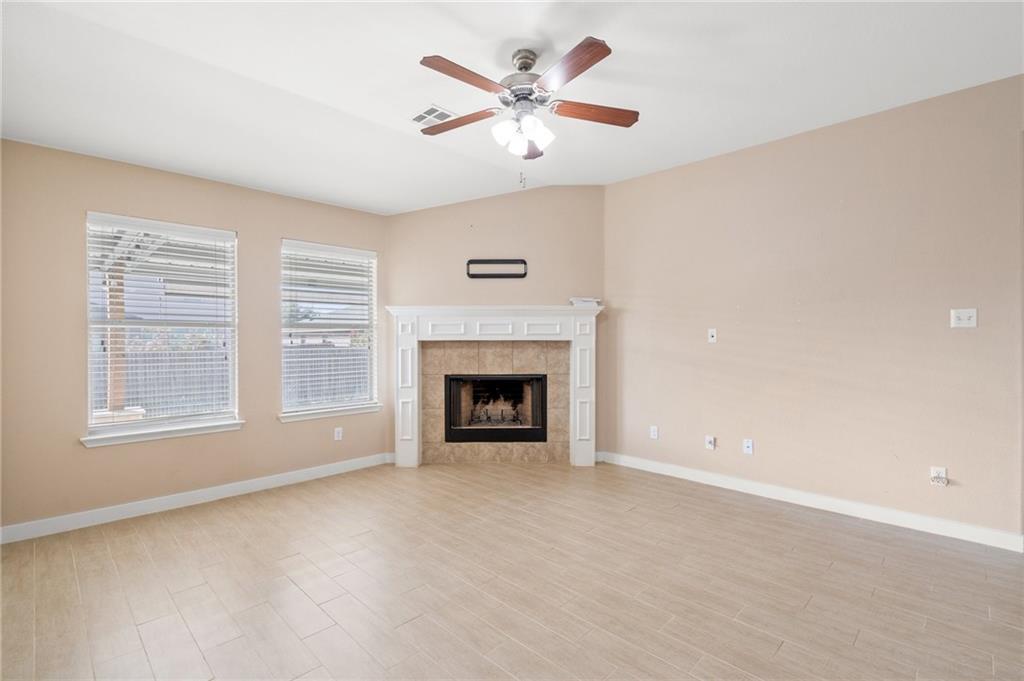 20224 Merlin Falcon Trail Pflugerville, TX 78660 - Photo 21 of 40 A comforting fireplace framed by elegant white millwork grounds this well-lit living area, perfect for relaxation.