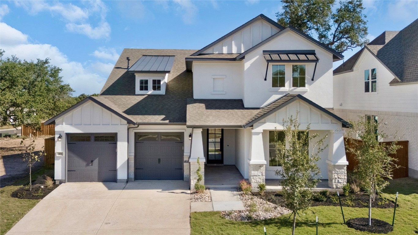 Modern farmhouse with board and batten siding, a shingled roof, driveway, a front lawn, and a standing seam roof