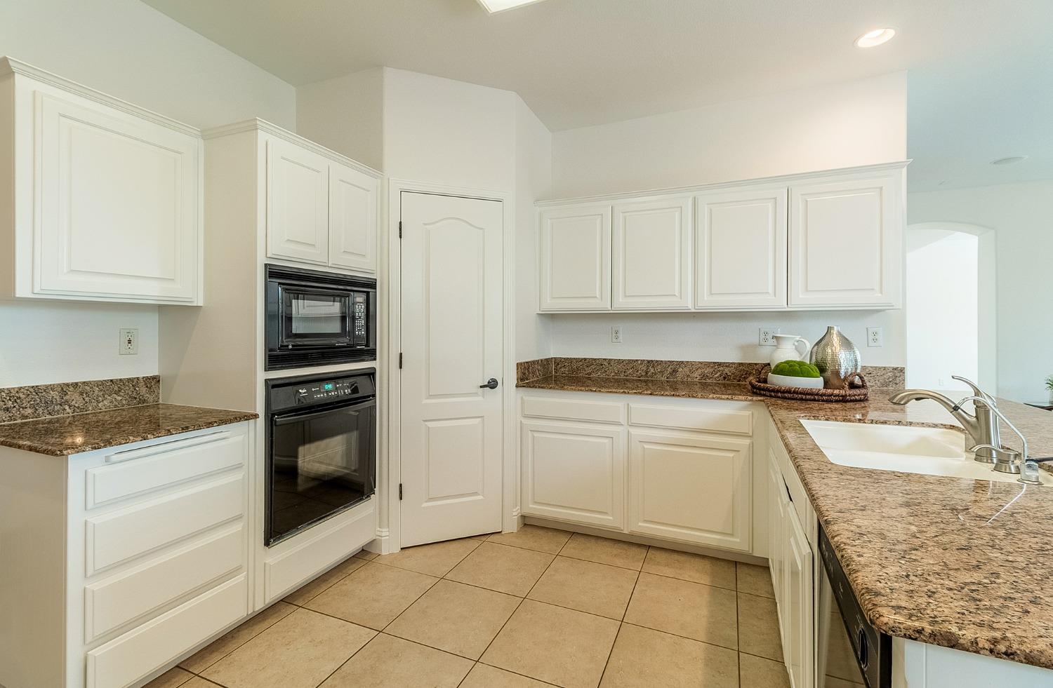 2595 Powers Avenue Coalinga, CA 93210 - Photo 12 of 34 a kitchen with granite countertop a sink stove and cabinets
