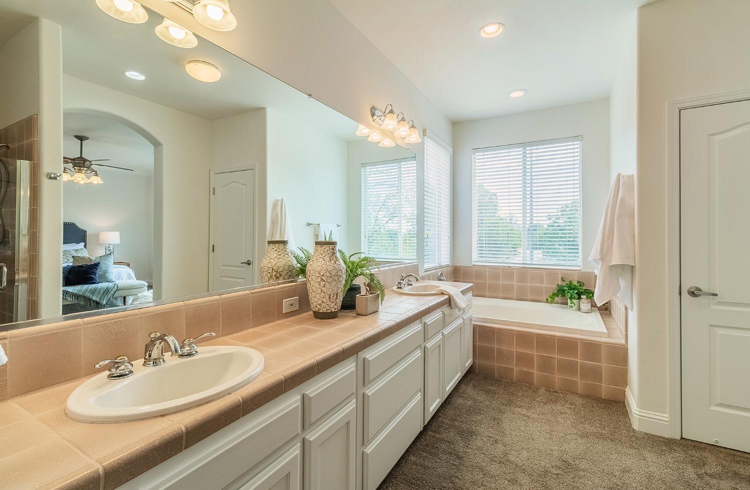 2595 Powers Avenue Coalinga, CA 93210 - Photo 26 of 34 a bathroom with a double vanity sink bathtub and a large mirror