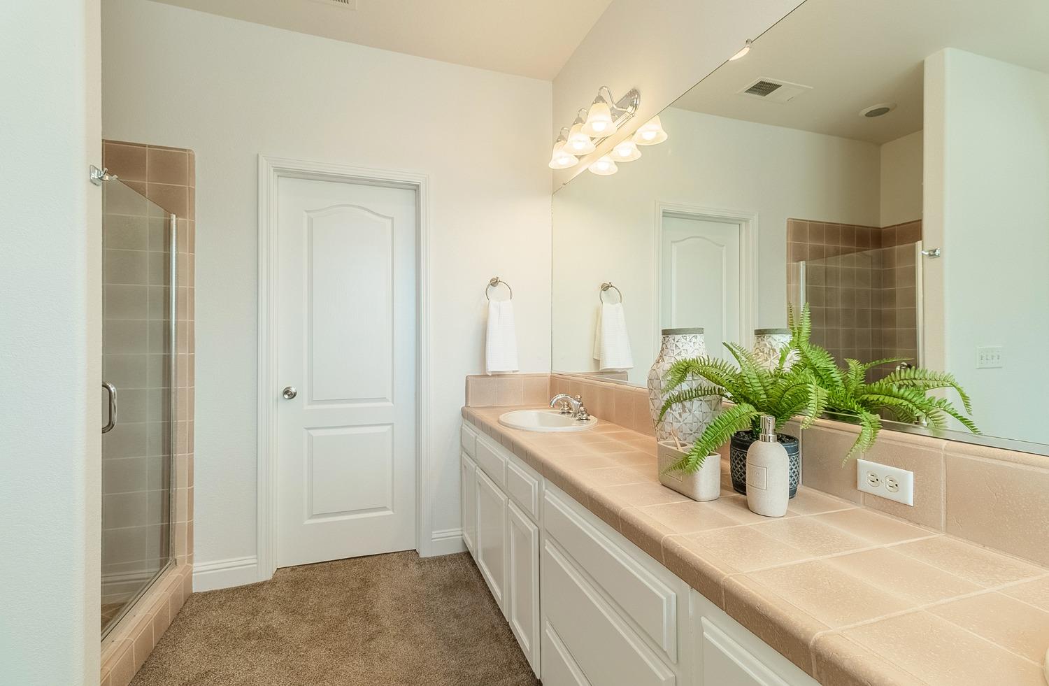 2595 Powers Avenue Coalinga, CA 93210 - Photo 27 of 34 a bathroom with a granite countertop sink a large mirror and a shower
