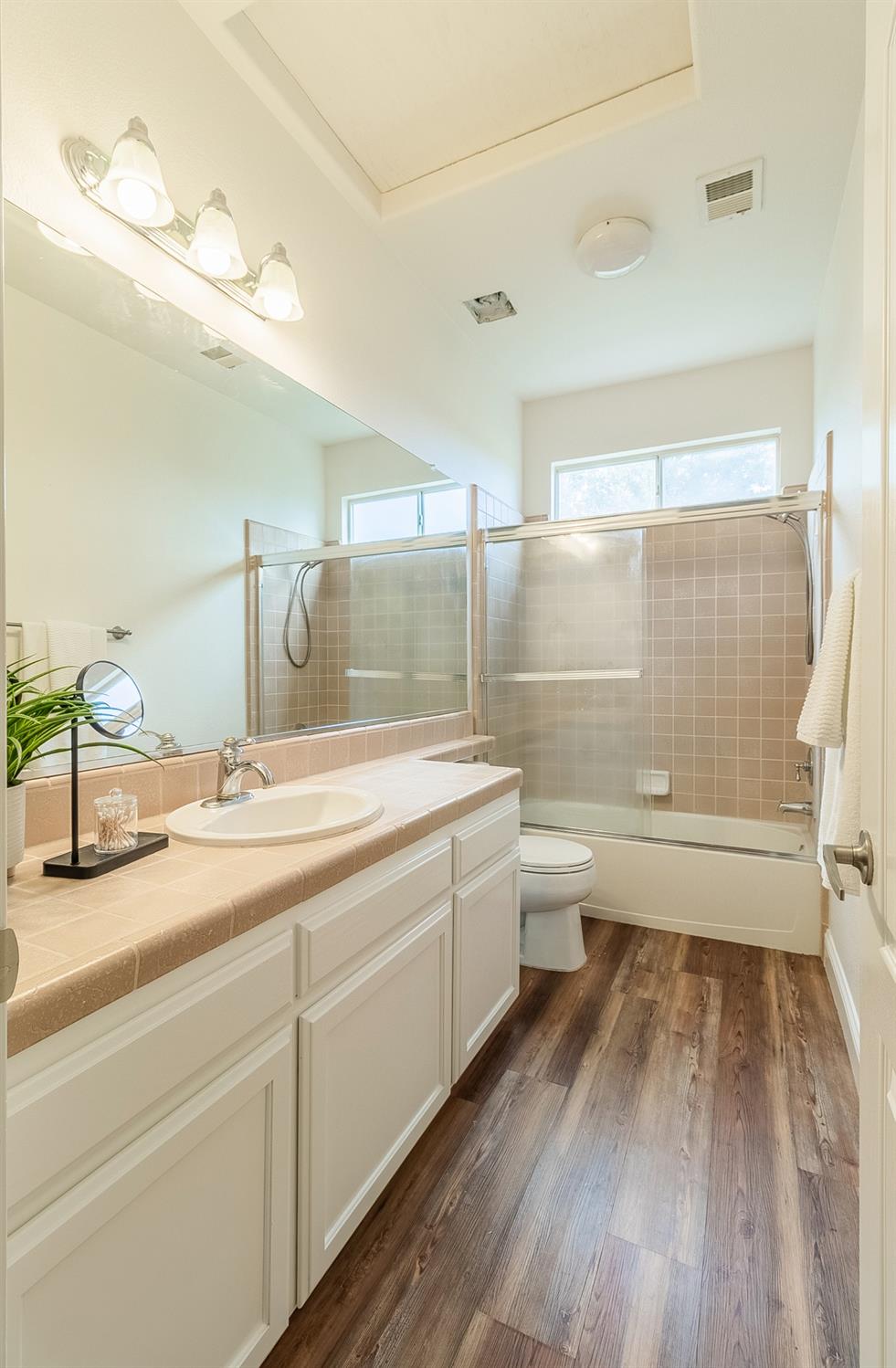 2595 Powers Avenue Coalinga, CA 93210 - Photo 30 of 34 a bathroom with a granite countertop sink toilet mirror vanity and shower