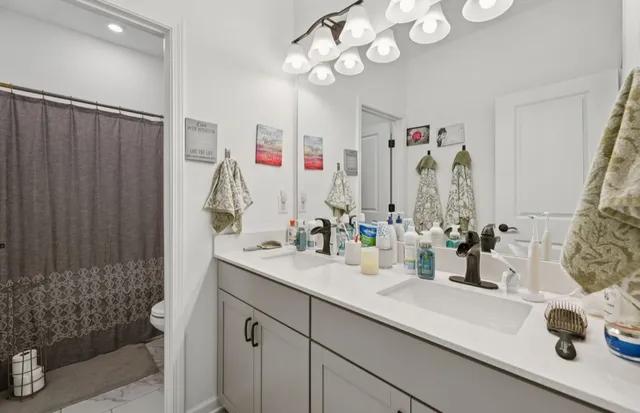 a bathroom with a double vanity sink mirror and shower