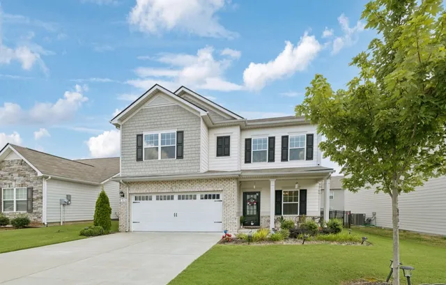 a view of a white house with a big yard and potted plants