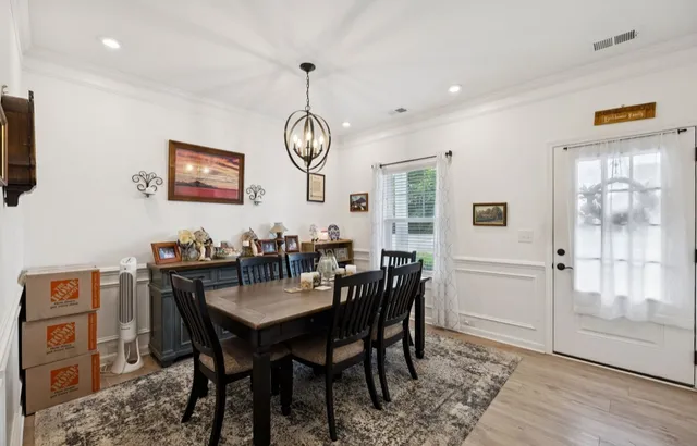 a kitchen with stainless steel appliances kitchen island granite countertop a table chairs and a refrigerator