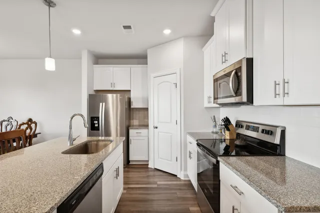 a kitchen with kitchen island a sink stove and refrigerator
