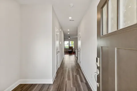 a view of a hallway with wooden floor and staircase