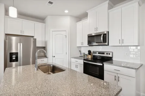 a kitchen with kitchen island a sink stainless steel appliances and cabinets