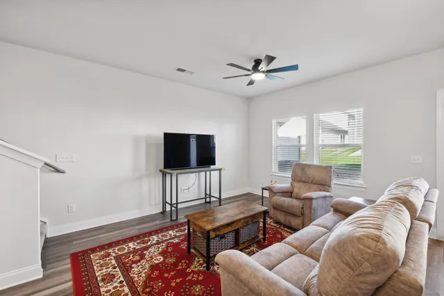 a living room with furniture a flat screen tv and a window