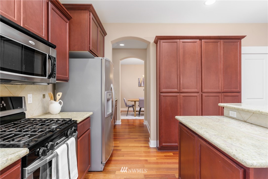 883 Jericho Place Northeast Renton, WA 98059 - Photo 11 of 30 a kitchen with granite countertop wooden cabinets and a stove top oven