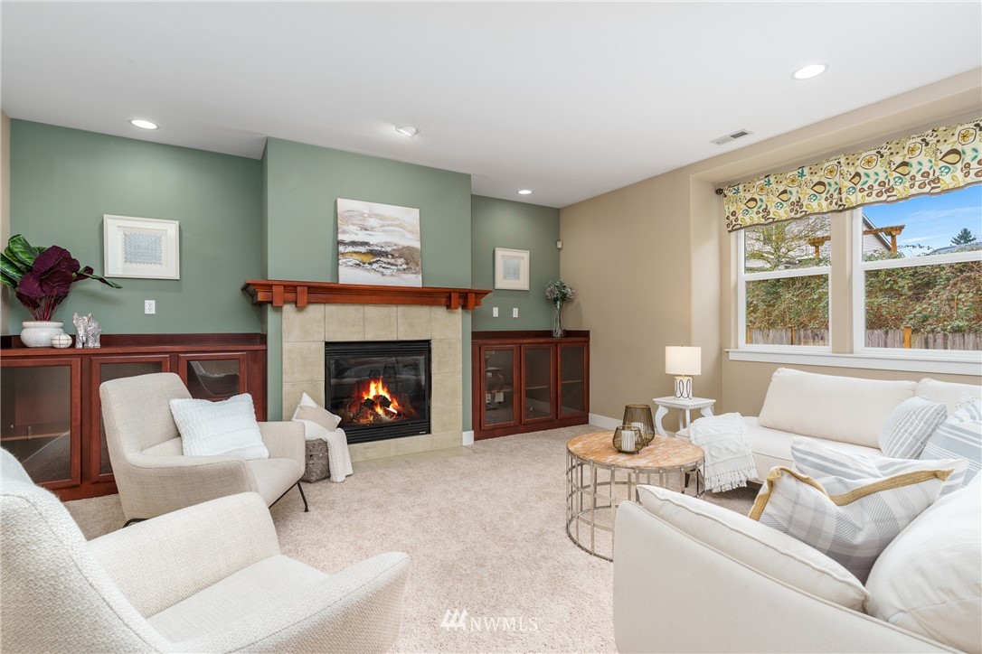883 Jericho Place Northeast Renton, WA 98059 - Photo 16 of 30 a living room with furniture a fireplace and a large window