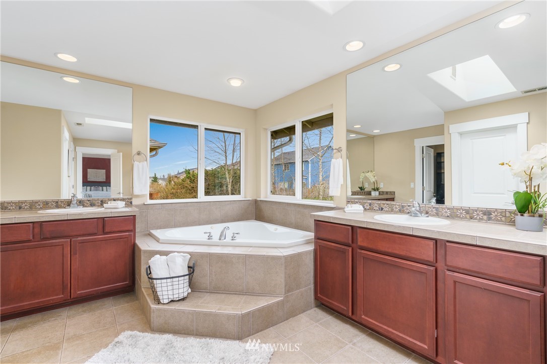 883 Jericho Place Northeast Renton, WA 98059 - Photo 22 of 30 a large spacious bathroom with a granite countertop tub sink and mirror