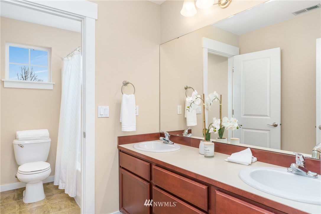 883 Jericho Place Northeast Renton, WA 98059 - Photo 25 of 30 a bathroom with a granite countertop sink toilet and shower