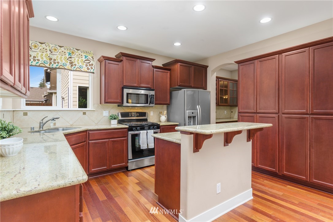 883 Jericho Place Northeast Renton, WA 98059 - Photo 10 of 30 a kitchen with granite countertop stainless steel appliances and wooden cabinets