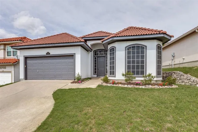 a front view of a house with a garden and garage