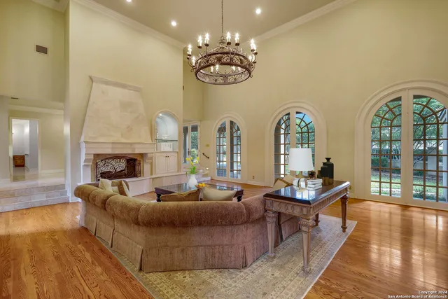 a living room with fireplace furniture and a large window