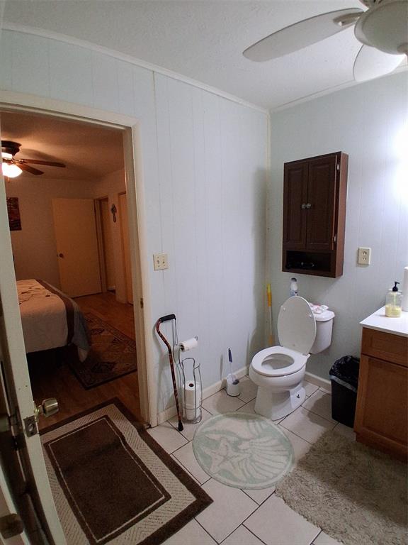 407 North Files Street Itasca, TX 76055 - Photo 14 of 30 Full bathroom with a ceiling fan, light tile patterned floors, vanity, crown molding, and wooden walls
