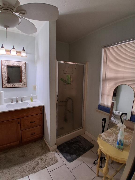 407 North Files Street Itasca, TX 76055 - Photo 15 of 30 Full bathroom with light tile patterned flooring, vanity, ornamental molding, a shower stall, and ceiling fan