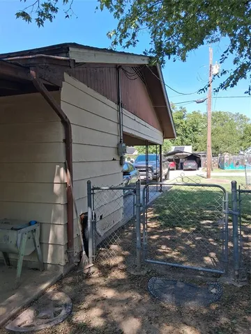 a front view of a house with a yard outdoor seating and covered with trees