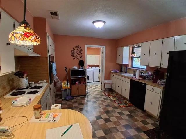 a kitchen with granite countertop a stove a sink a dining table and chairs