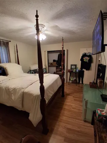 a bedroom with bed chair and wooden floor