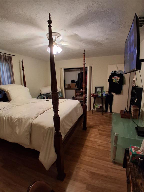 407 North Files Street Itasca, TX 76055 - Photo 7 of 30 Bedroom featuring a textured ceiling, wood finished floors, and a ceiling fan