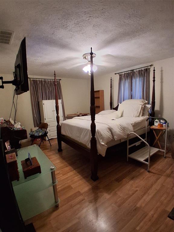 407 North Files Street Itasca, TX 76055 - Photo 8 of 30 Bedroom featuring wood finished floors and a textured ceiling