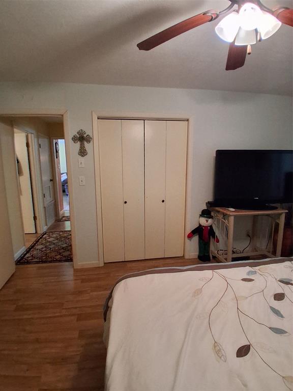 407 North Files Street Itasca, TX 76055 - Photo 10 of 30 Bedroom featuring wood finished floors, a closet, and ceiling fan