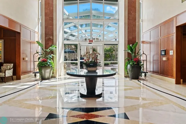 a view of a living room with a large window and potted plants