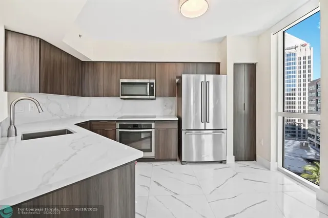 a kitchen with stainless steel appliances a refrigerator sink and microwave