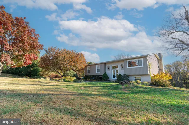 a view of a house with a big yard and large trees