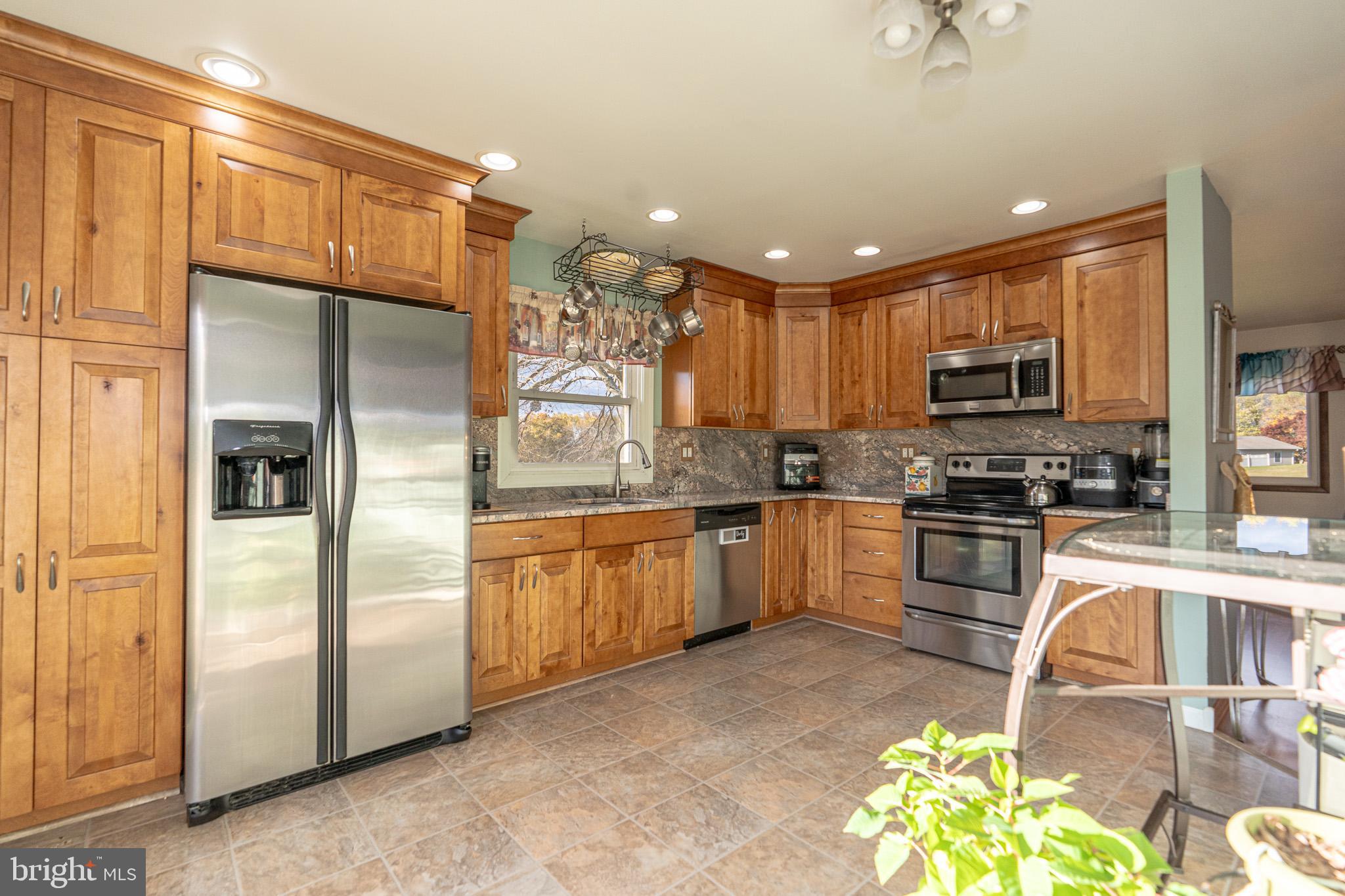 1913 Trout Farm Road Jarrettsville, MD 21084 - Photo 21 of 40 a kitchen with granite countertop a refrigerator a sink a stove top oven a dining table and chairs
