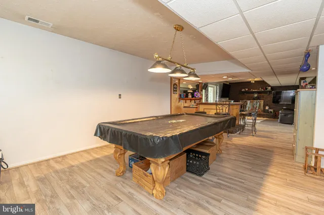 a view of a kitchen with kitchen island a sink a counter space and stainless steel appliances