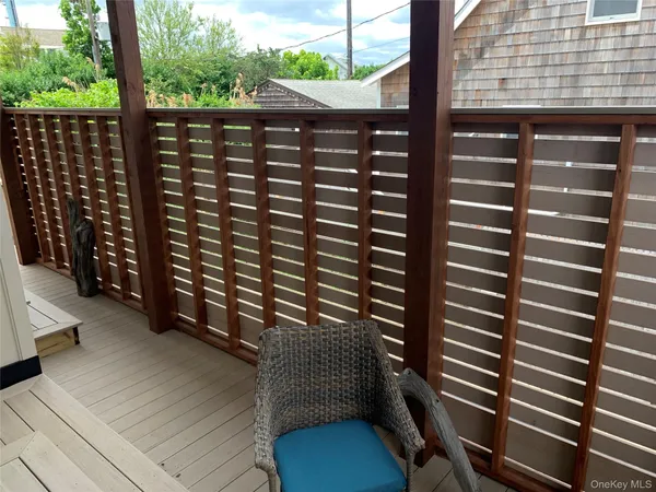 a view of a balcony with wooden floor and outdoor seating
