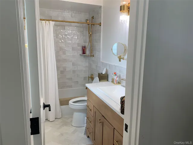 a bathroom with a sink a toilet and shower curtain