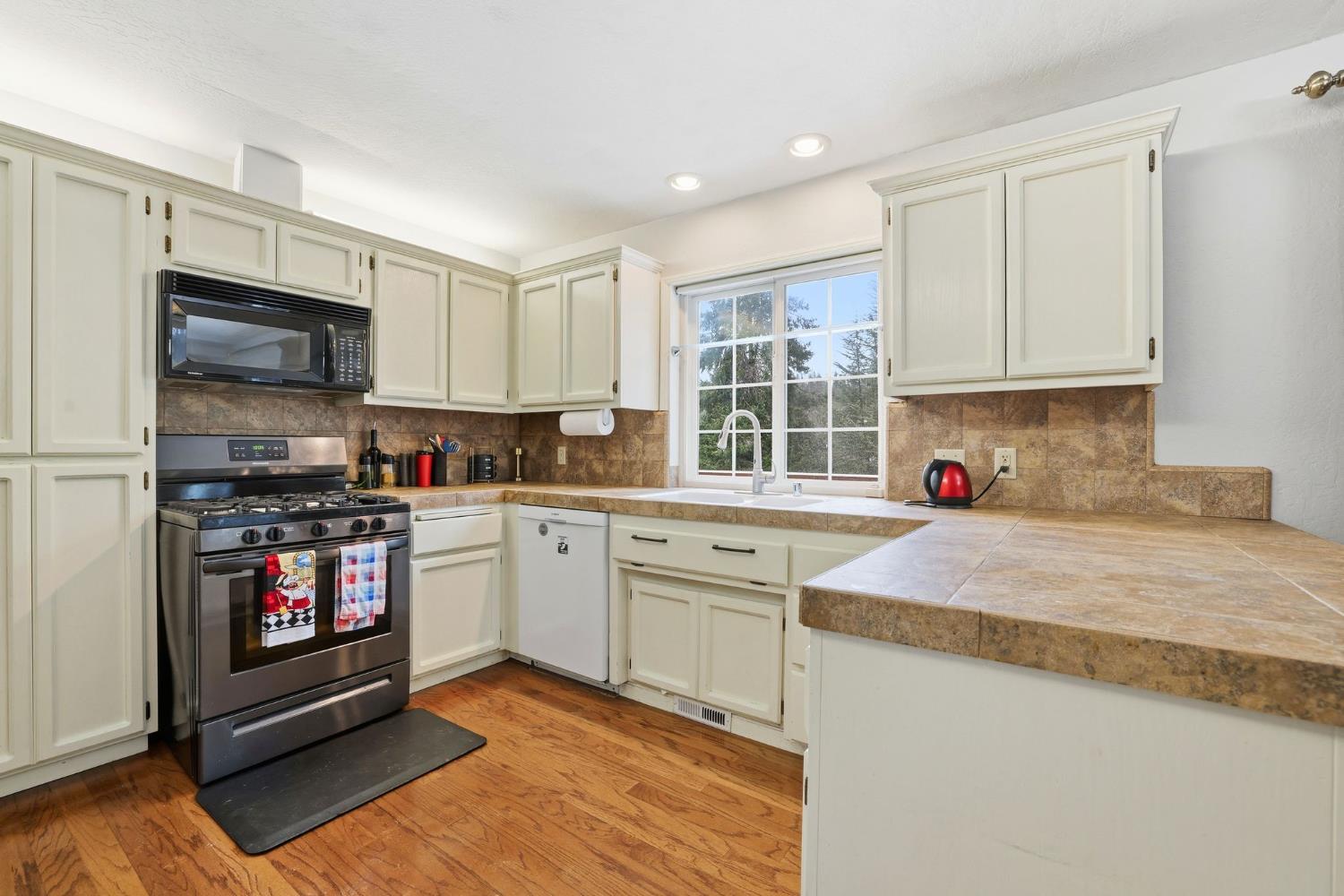 11002 Ball Road Grass Valley, CA 95949 - Photo 9 of 34 a kitchen with granite countertop a stove top oven a sink dishwasher and a refrigerator with wooden cabinets