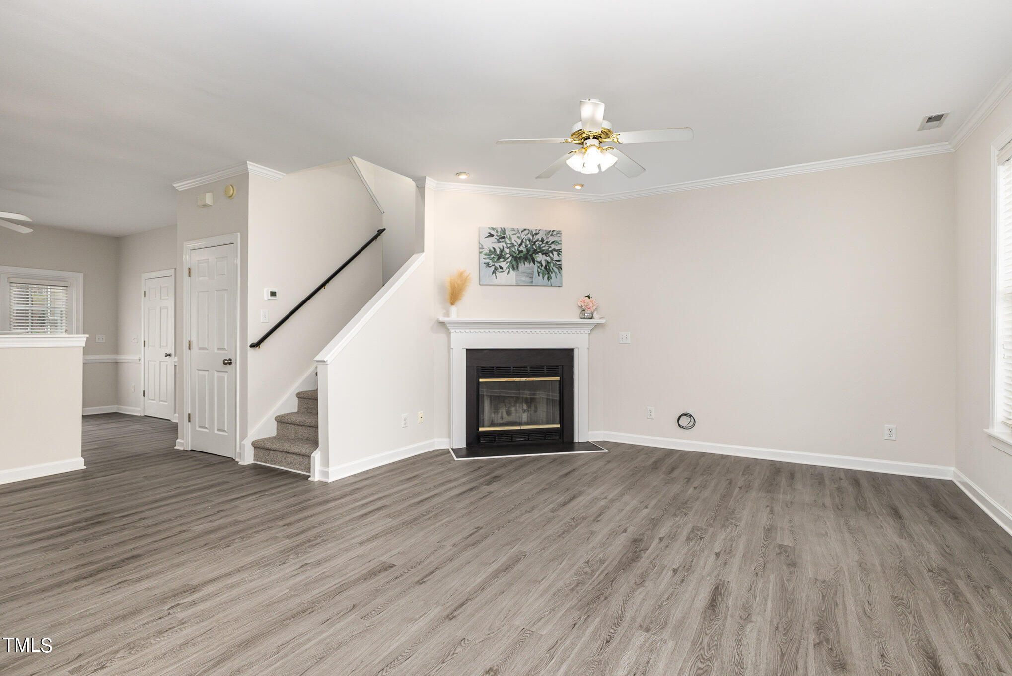 7323 Bonnie Ridge Court Raleigh, NC 27615 - Photo 3 of 12 a view of an empty room with wooden floor fireplace and a window