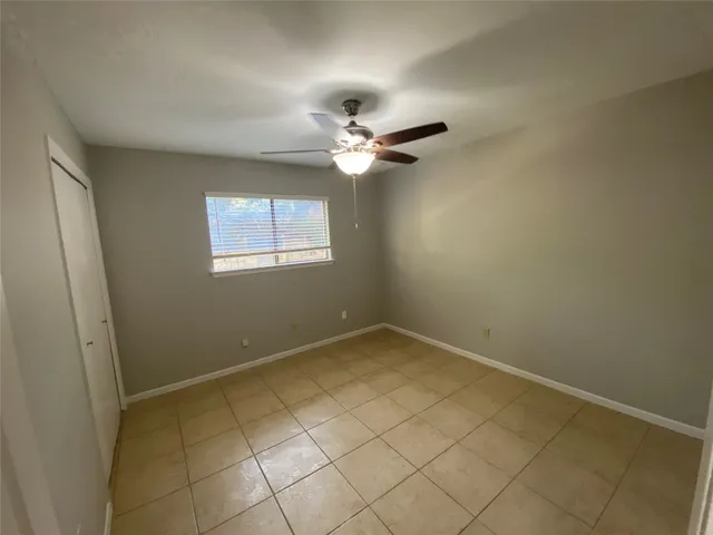 a view of an empty room with a chandelier fan