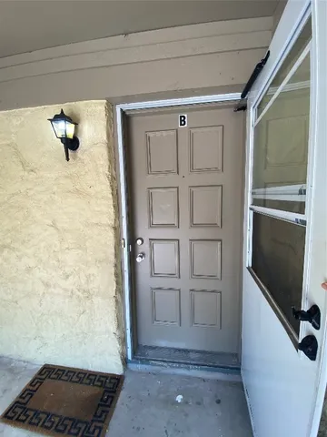 a view of a house with backyard and a tree