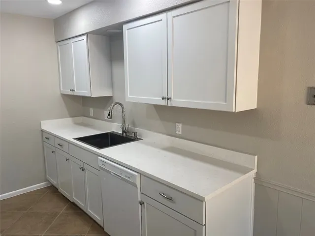 a kitchen with white cabinets and white appliances
